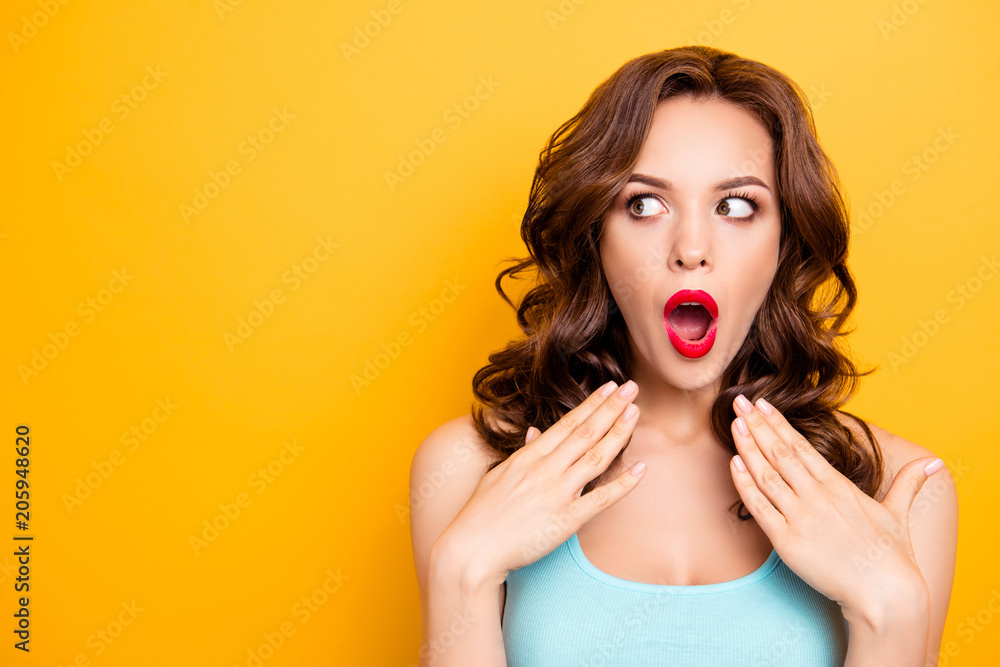 Portrait with copy space for advertisement of shocked afraid woman looking with eyes at empty place having wide open mouth eyes gesturing palms isolated on yellow background - obrazy, fototapety, plakaty 
