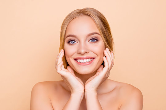 Nude, charming, pretty, cute, toothy cheerful girl with beaming smile perfect face skin after detox, vitamins, collagen holding hands on cheek, isolated on beige background, wellness wellbeing concept