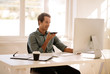 © Jacob Lund - Entrepreneur talking on mobile phone while working on computer a
