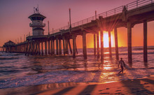 Silhouette Of A Surfer At Sunset In Front Of The Huntington Beach Pier In California