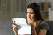 Sad woman complaining reading a letter in the night
