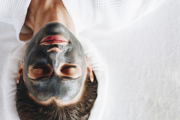 Woman relaxing with a charcoal facial mask