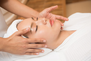 Face massage. Spa skin and body care. Close-up of young woman getting spa massage treatment at beauty spa salon. Facial beauty treatment.