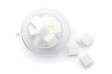 Wall Mural - White cube sugar in a glass cup on white background. Top view.