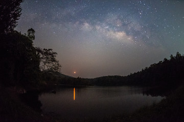 Wall Mural - milky way band across sky and moonrise over reservoir.