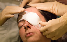 Doctor Covering Eye Of Patient By Medical Plaster