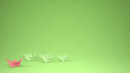 Origami pink paper crane leading group of cranes, leadership motivation concept idea with copy space, green background