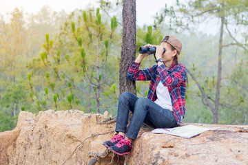 Female hikers take a look at the map and use binoculars.