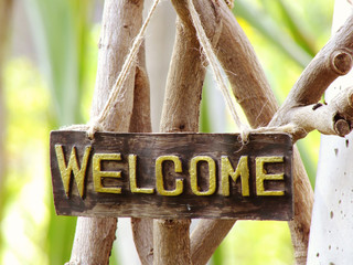 welcome sign hanging in the garden