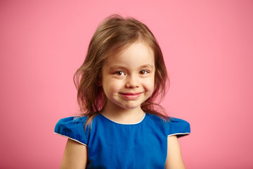 Wall Mural - portrait of beautiful child girl with charming look on isolated blue background.