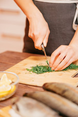 Wall Mural - Woman cutting greenery for fish dish.