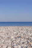 Fototapeta Paryż - Pebble stony beach and blue wave sea with clean sky