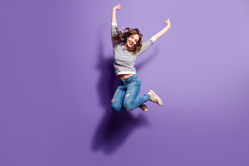 portrait of cheerful positive girl jumping in the air with raised fists looking at camera isolated o