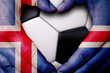 Hands painted with an Iceland flag forming a heart over soccer ball background