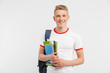 © Drobot Dean - Image of european student boy wearing backpack smiling and looking at you with textbooks in hands, isolated over white background