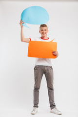 Sticker - Full length photo of pleased advertiser boy wearing casual t-shirt holding two blank message bubbles copyspace for your text, isolated over white background