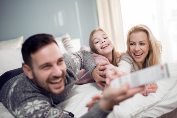 Wall Mural - Young family watching television together