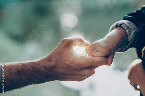 father and little son holding hands in sunlight Poster Mural XXL