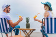 © Mediteraneo - Couple on a deck chair relaxing on the beach. Happy couple enjoy on the beach during summer vacations