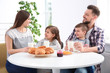 © New Africa - Happy family having breakfast with milk at table