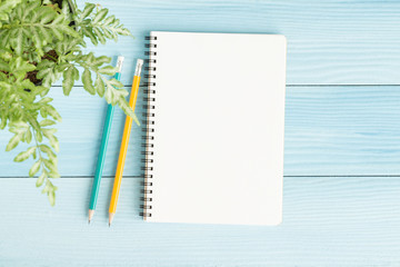 Wall Mural - blank notebook with and pencil on blue background,flat lay photo of notebook for your message