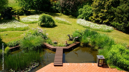 naturbelassener Gartenteich mit Brücke und Margeritenwiese an ... naturbelassener Gartenteich mit Brücke und Margeritenwiese an ...