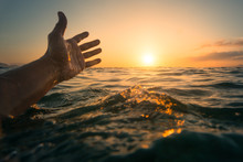 Hand Showing The Sunset When Swimming In The Sea