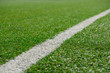 © bravissimos - White stripe on Artificial green football soccer field from side view.