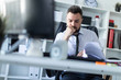 © Ivan Traimak - A man is sitting in the office and scrolls through the documents. photo with depth of field, highlighted focus on man.