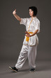 © soleg - Young woman practicing tai chi chuan. Chinese management skill Qi's energy. Gray background, studio shoot.