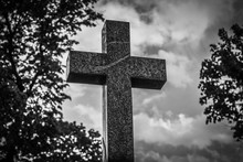 Black White Shot Of A Stone Cross On The Background Of Trees - The Concept Of Christian Faith