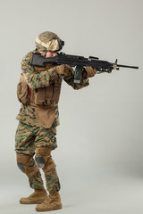 Wall Mural - Soldier in camouflage holding rifle