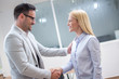 © Bojan - Business woman and man shaking hands after successful meeting in office.