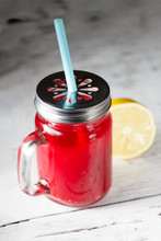 Red Drink In A Mason Jar On White Wooden Background