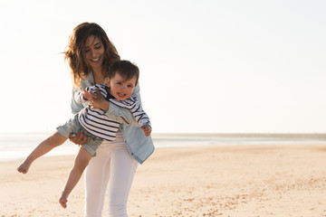 Wall Mural - Mother at the beach with toddler