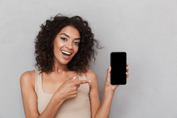 portrait of a smiling young african woman pointing