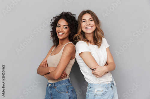 Portrait of two cheerful young women standing together Tableau sur Toile