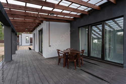 Fotomural Side view of an open veranda in front of a modern forest cottage