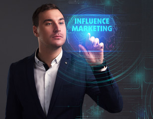 Business, Technology, Internet and network concept. Young businessman working on a virtual screen of the future and sees the inscription: Influence marketing