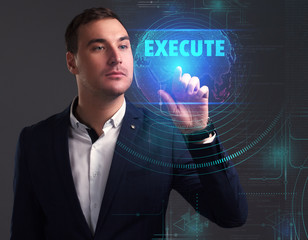 Business, Technology, Internet and network concept. Young businessman working on a virtual screen of the future and sees the inscription: Execute