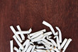 © rahwik - Cigarette butts on wooden background top view. Copy space