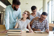 © NDABCREATIVITY - Young happy students sitting in library