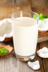 Wall Mural - Coconut and coconut milk in glass, mint on wooden old table.