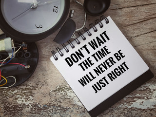 Wall Mural - Motivational and inspirational quote - ‘Don’t wait, the time will never be just right’ written on a white open notebook.With vintage styled background.