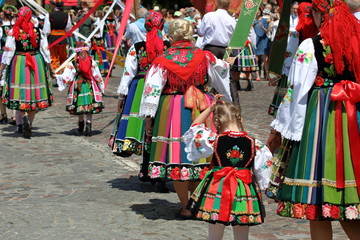 Local people in traditional folk costumes from Lowicz region in Poland walk in Corpus Christi procession