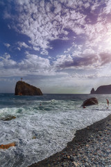 Wall Mural - Rocky seashore and waves on a sunny day