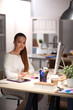 © shefkate - Young woman working in office, sitting at desk. Young woman.