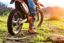Man Riding A Motocross In A Protective Suit In The Mud