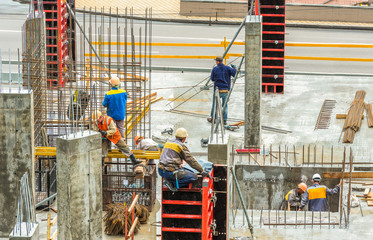 Construction workers are working on a construction site in Kiev, Ukraine. Concrete construction works and assembly of metal structures are carried out.