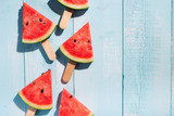 Slices of watermelon on blue wooden desk.